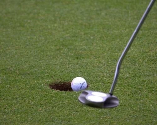 Lähikuva golf-kentästä, mailasta ja pallosta
